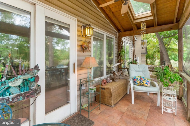 sunroom / solarium with plenty of natural light, ceiling fan, lofted ceiling with skylight, and wooden ceiling