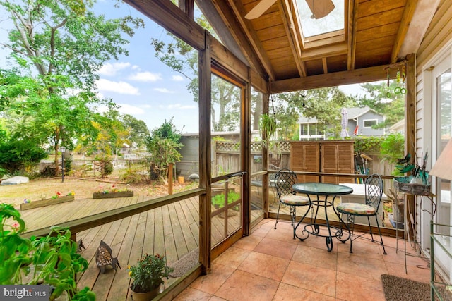 sunroom featuring lofted ceiling with skylight, ceiling fan, and wood ceiling