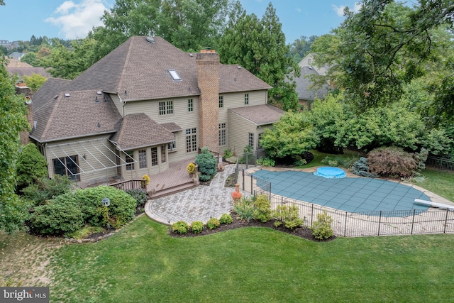 view of swimming pool featuring a deck and a yard