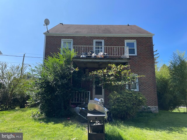 view of front of property with a front lawn and a balcony