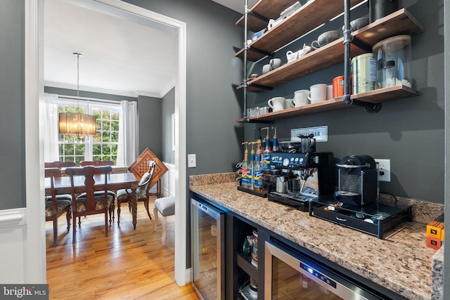 interior space with light hardwood / wood-style floors, light stone counters, beverage cooler, and crown molding