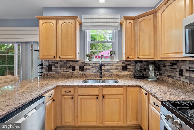 kitchen featuring light brown cabinetry, backsplash, stainless steel appliances, and sink