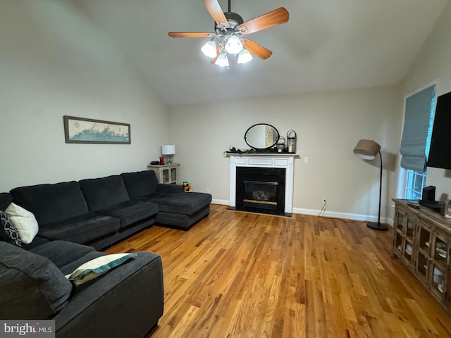 living room with light hardwood / wood-style flooring, ceiling fan, and lofted ceiling