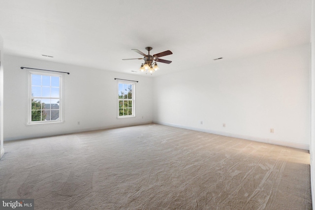 carpeted spare room featuring ceiling fan