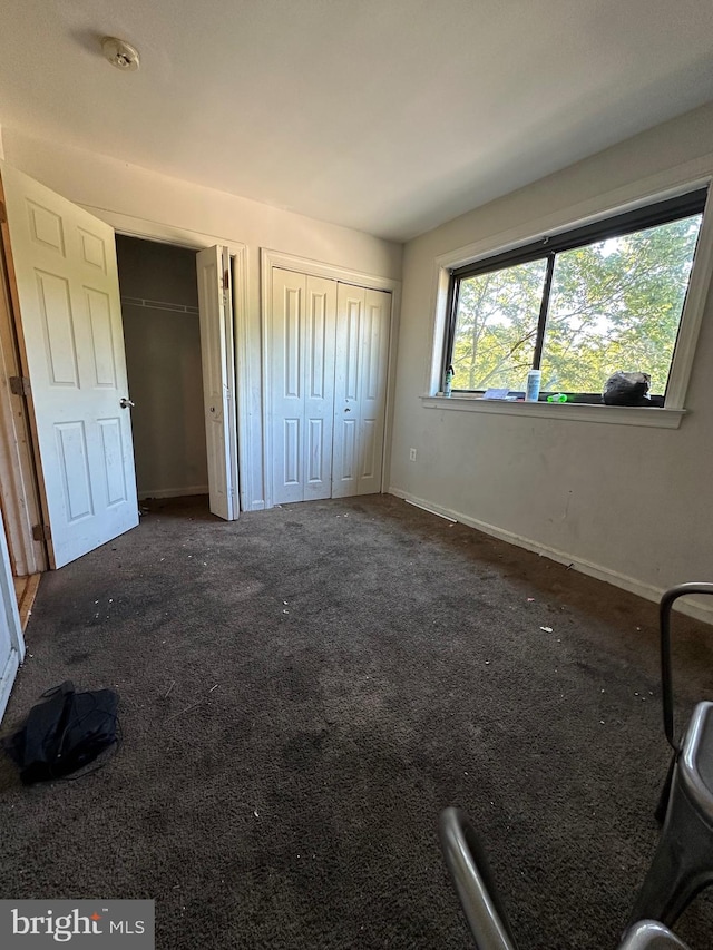 unfurnished bedroom featuring dark colored carpet