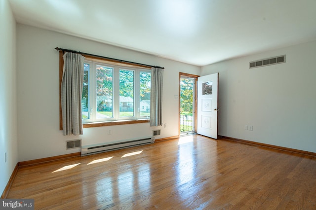 spare room with a baseboard radiator and light hardwood / wood-style flooring