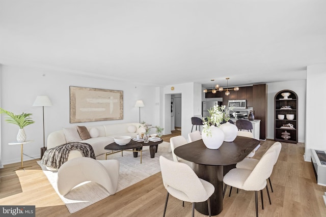 dining area with an inviting chandelier and light hardwood / wood-style floors