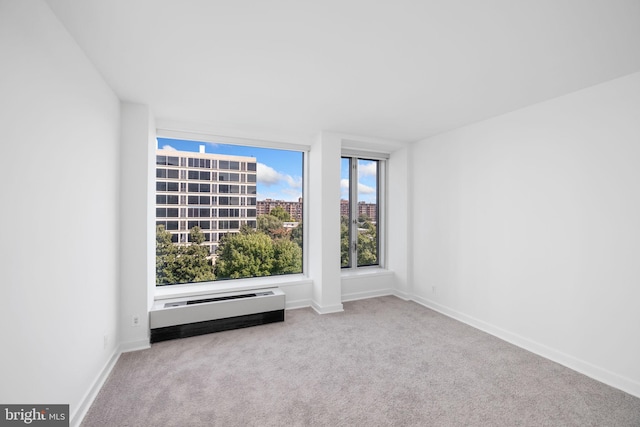 carpeted spare room featuring a baseboard heating unit