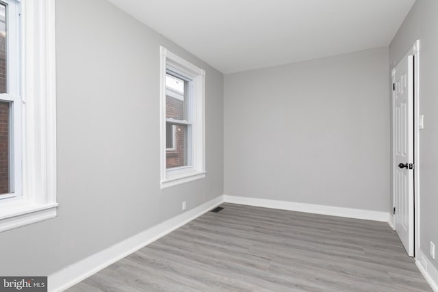 empty room featuring light wood-type flooring and a healthy amount of sunlight