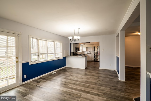 interior space with dark hardwood / wood-style flooring, plenty of natural light, and an inviting chandelier