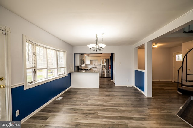 unfurnished dining area with dark wood-type flooring and a chandelier