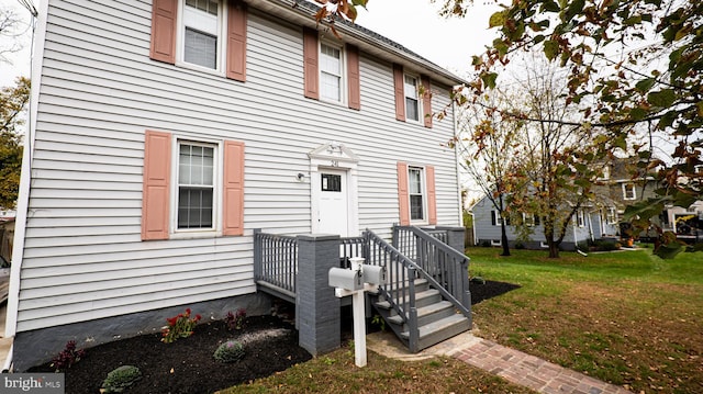 rear view of property featuring a yard