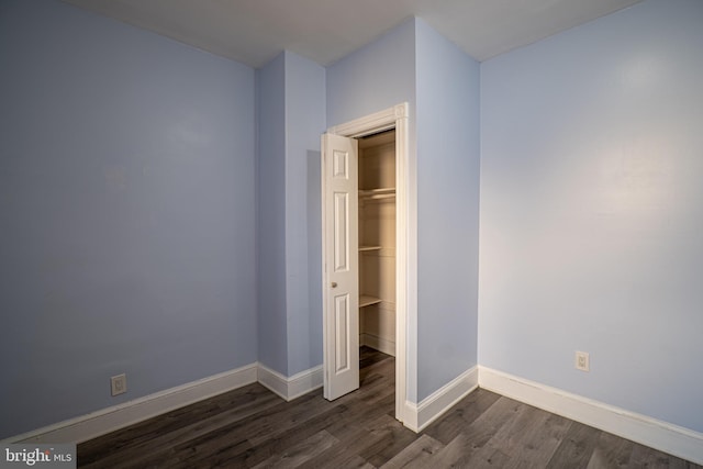 unfurnished bedroom featuring dark wood-type flooring and a closet