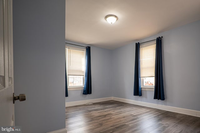 spare room featuring dark wood-type flooring