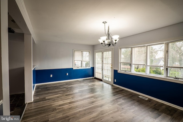 spare room featuring crown molding, dark hardwood / wood-style flooring, and a notable chandelier