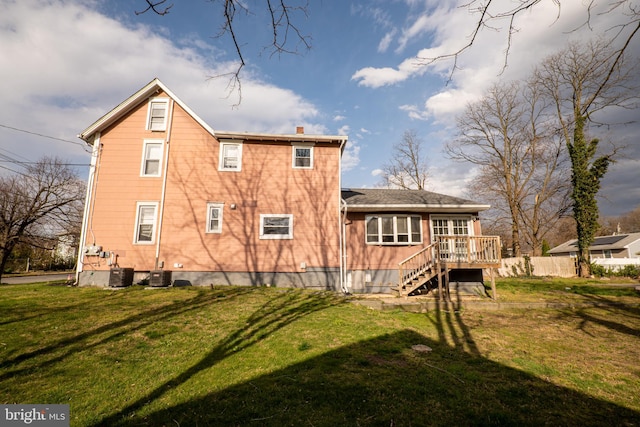 back of property with central AC unit, a yard, and a deck