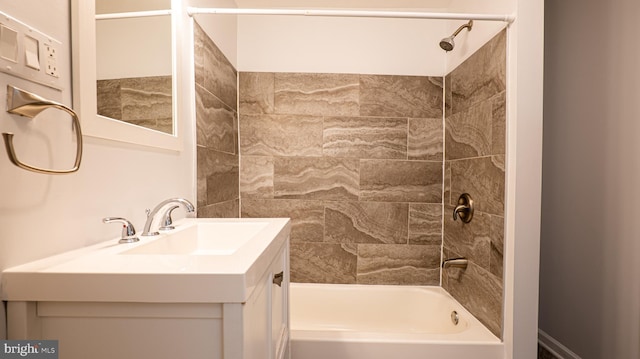 bathroom with tiled shower / bath combo and vanity