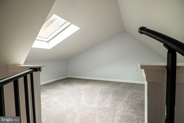 additional living space with carpet flooring and vaulted ceiling with skylight