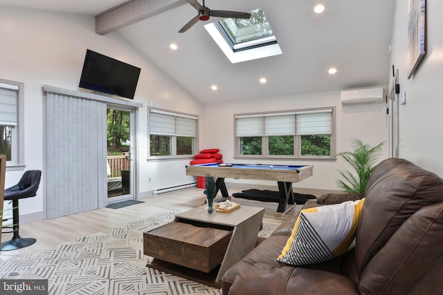 playroom featuring a skylight, light hardwood / wood-style flooring, a wall mounted air conditioner, and a wealth of natural light