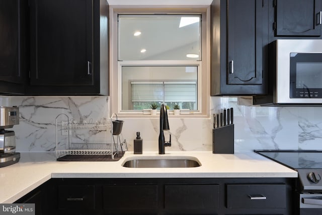 kitchen featuring decorative backsplash, electric stove, and sink