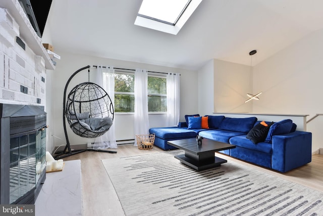 living room with light wood-type flooring, a baseboard heating unit, and a skylight