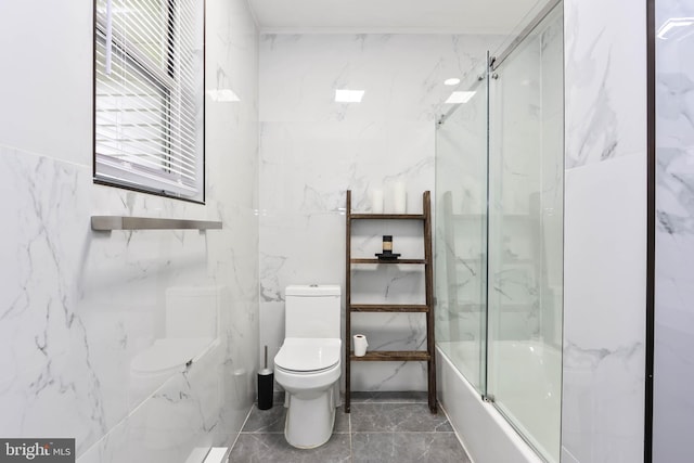 bathroom featuring bath / shower combo with glass door and toilet