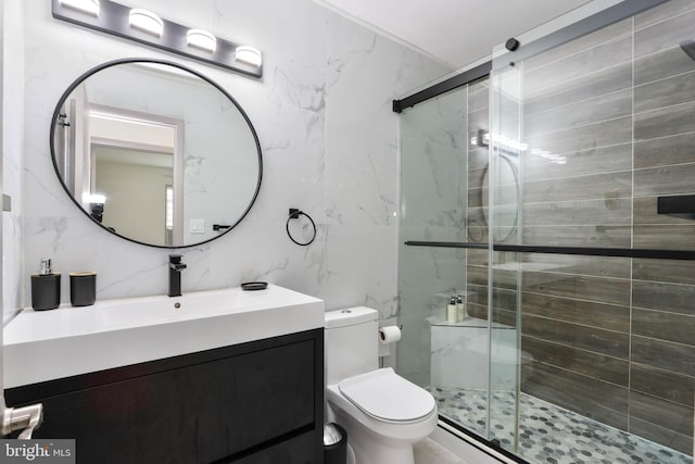 bathroom with tile walls, a shower with shower door, vanity, and toilet