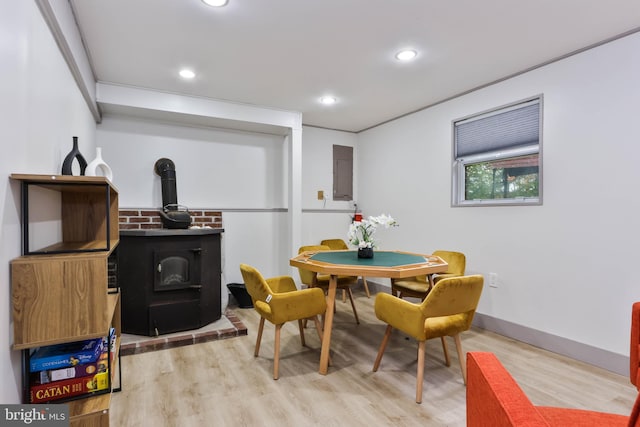 dining room featuring a wood stove, electric panel, and hardwood / wood-style flooring