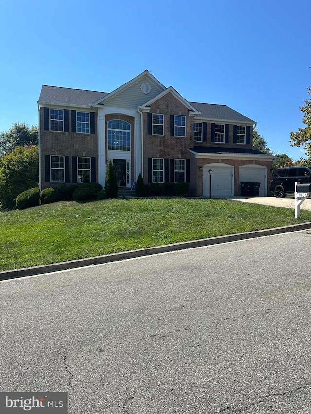 view of front of property featuring a front yard and a garage