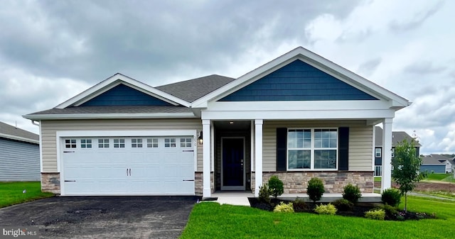 craftsman inspired home with a front yard, a garage, and a porch