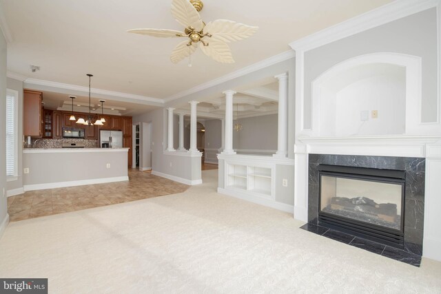 unfurnished living room with carpet flooring, a tray ceiling, a high end fireplace, and ornamental molding