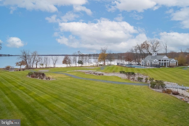 view of home's community with a lawn and a water view