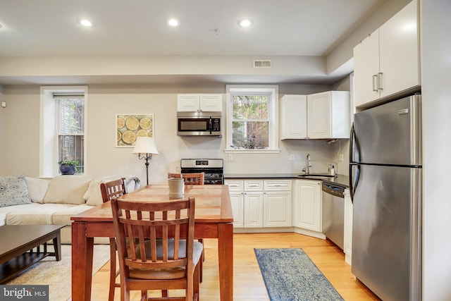 kitchen featuring white cabinets, stainless steel appliances, and a healthy amount of sunlight