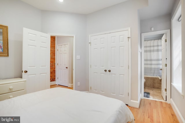 bedroom featuring light wood-type flooring and two closets