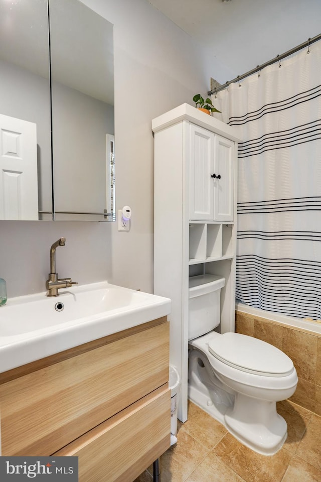 bathroom featuring tile patterned flooring, walk in shower, vanity, and toilet