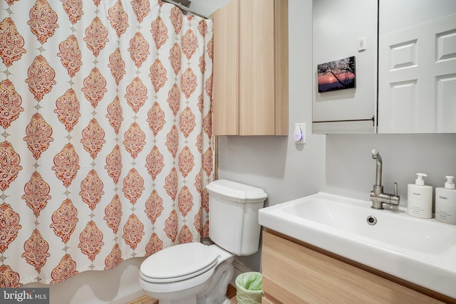 bathroom with curtained shower, vanity, and toilet