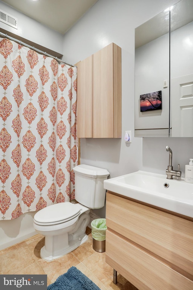 bathroom featuring tile patterned flooring, vanity, and toilet