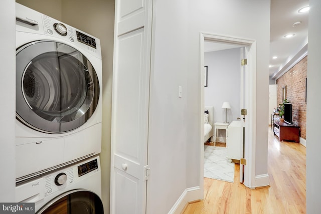 washroom featuring stacked washer / dryer and light wood-type flooring