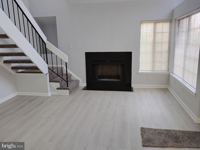 unfurnished living room featuring a wealth of natural light and light hardwood / wood-style flooring