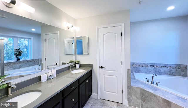 bathroom featuring vanity and tiled bath