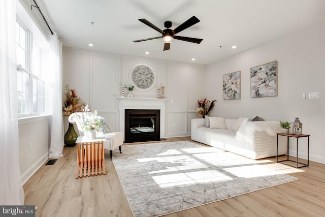 living room with ceiling fan and light wood-type flooring