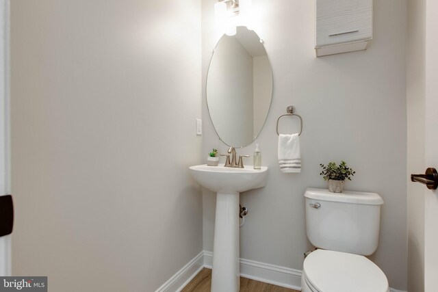 bathroom with toilet and hardwood / wood-style flooring