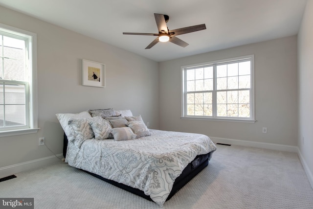 carpeted bedroom featuring ceiling fan and multiple windows