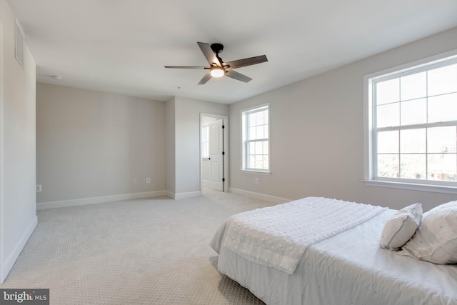 carpeted bedroom with multiple windows and ceiling fan