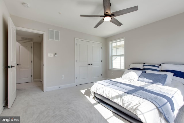 bedroom featuring a closet, light colored carpet, and ceiling fan