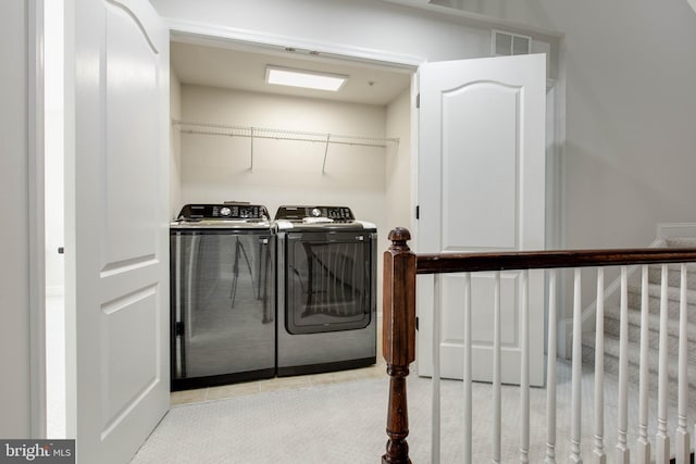 clothes washing area featuring separate washer and dryer and light colored carpet