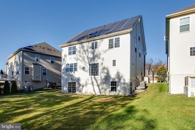 rear view of house featuring central AC and a lawn