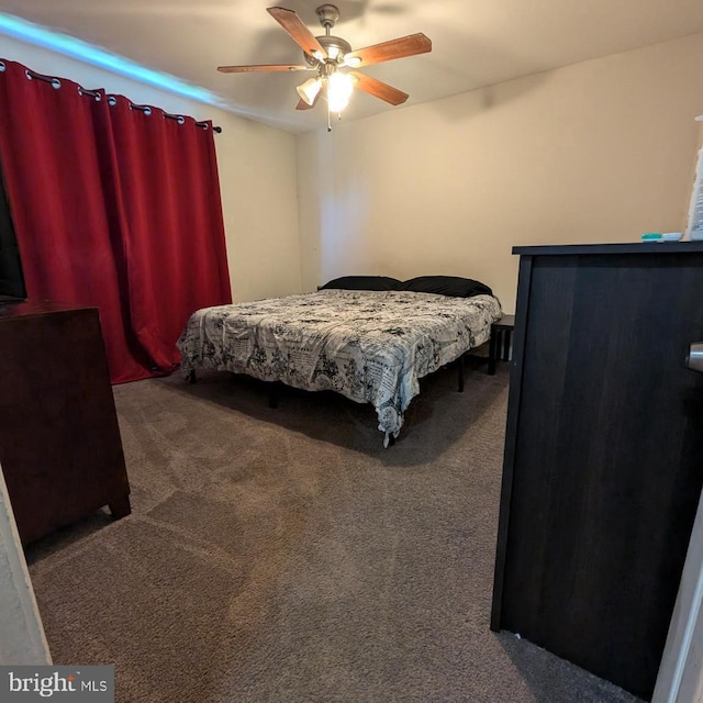 bedroom with ceiling fan and dark colored carpet