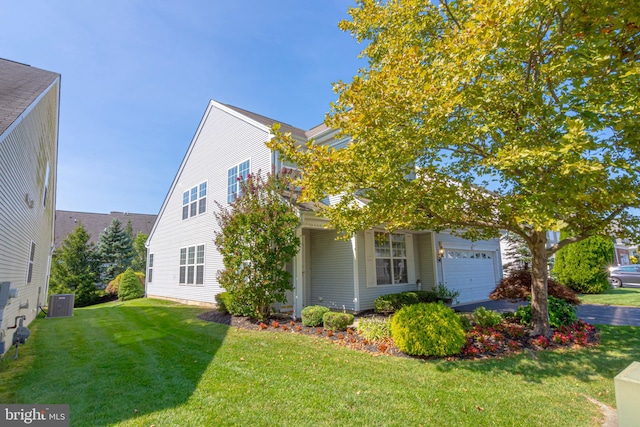 view of front of property with a garage, central AC, and a front yard