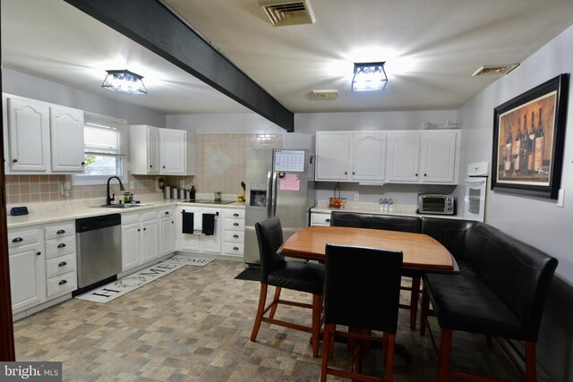 kitchen featuring white oven, backsplash, stainless steel fridge with ice dispenser, black electric cooktop, and white cabinets